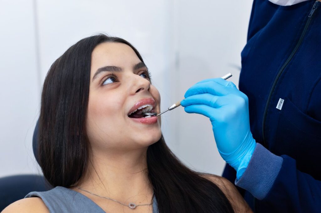 Female dentist examining young woman's teeth in a modern clinic setting in Belo Horizonte, Brazil.